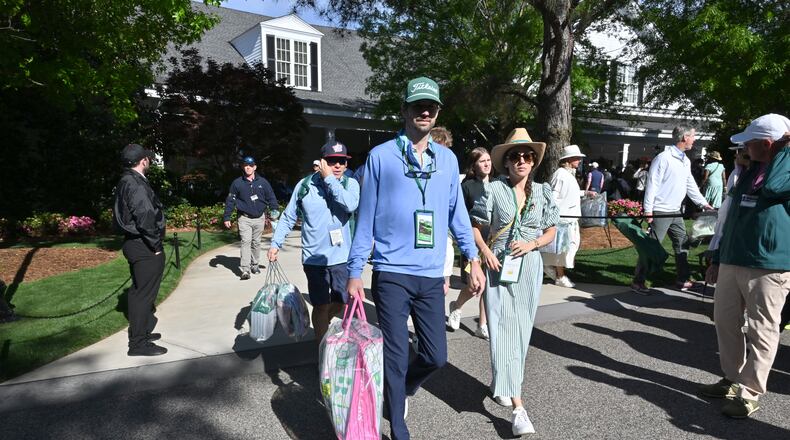 Patrons emerge from the Golf Shop at Augusta National with bags of merchandise to commemorate their Masters experience. (Hyosub Shin/AJC)