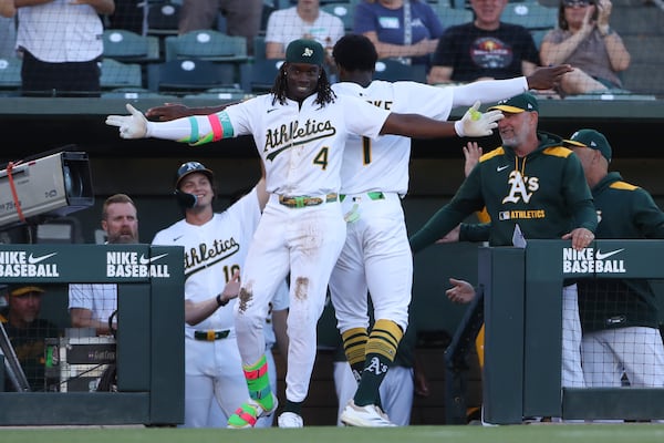 Athletics' Lawrence Butler (4) celebrates with teammate Denzel Clarke (1) after hitting an inside-the-park home run against the Atlanta Braves during the first inning of a baseball game Tuesday, July 8, 2025, in West Sacramento, Calif. (AP Photo/Scott Marshall)