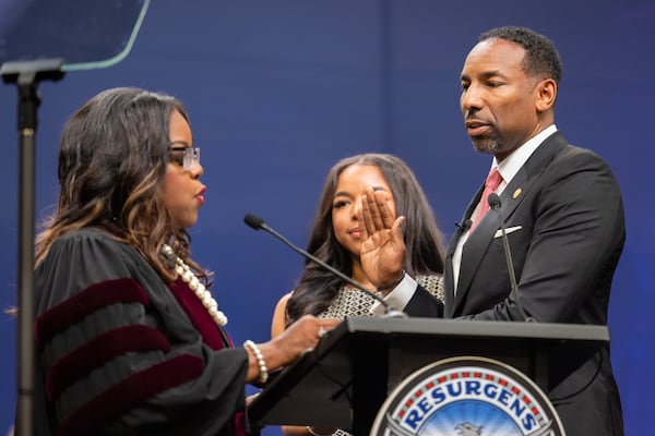Atlanta Mayor Andre Dickens, accompanied by his daughter Bailey, is sworn in by Judge Asha Jackson for a second term during a ceremony in Atlanta on Monday. (Arvin Temkar/AJC)