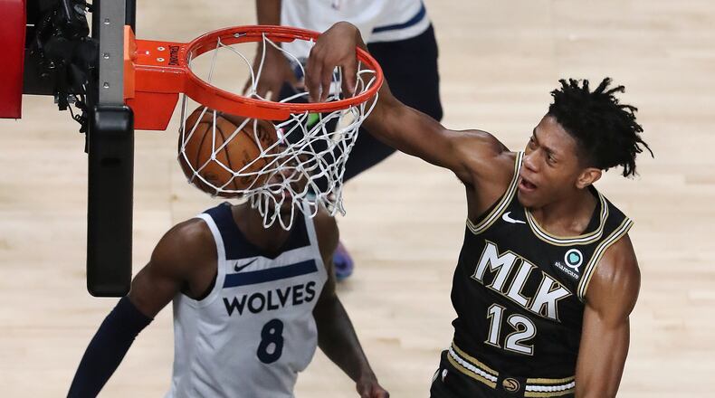 Hawks forward De’Andre Hunter finishes up a dunk over Minnesota Timberwolves forward Jarred Vanderbilt. (Curtis Compton / Curtis.Compton@ajc.com)