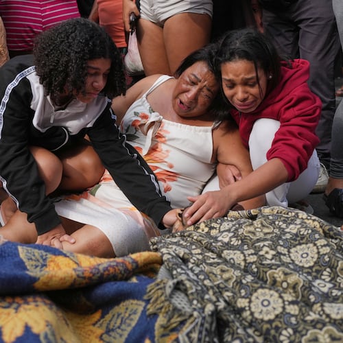 Relatives mourn over the bodies of people killed the day before during a police raid targeting the Comando Vermelho gang in the Complexo da Penha favela of Rio de Janeiro, Brazil, Wednesday, Oct. 29, 2025. (AP Photo/Silvia Izquierdo)