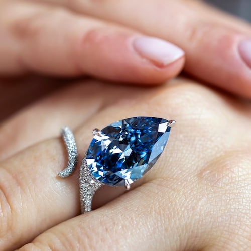 A Christie's employee displays the Mellon Blue, a fancy vivid blue pear-shaped diamond of 9.51 carats, during a preview at Christie's in Geneva, Switzerland, Friday, Nov. 7, 2025, ahead of an auction where it is estimated to sell for between 20 and 30 million US dollars. (Martial Trezzini/Keystone via AP)