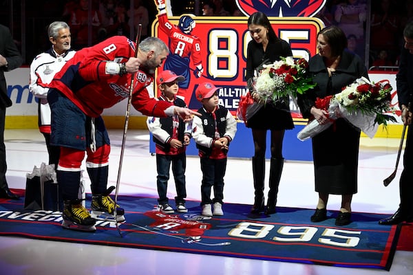Washington Capitals left wing Alex Ovechkin (8) talks to his family as they take part in a ceremony to honor him for scoring 895 career NHL goals before an NHL hockey game against the Carolina Hurricanes, Thursday, April 10, 2025, in Washington. (AP Photo/Nick Wass)