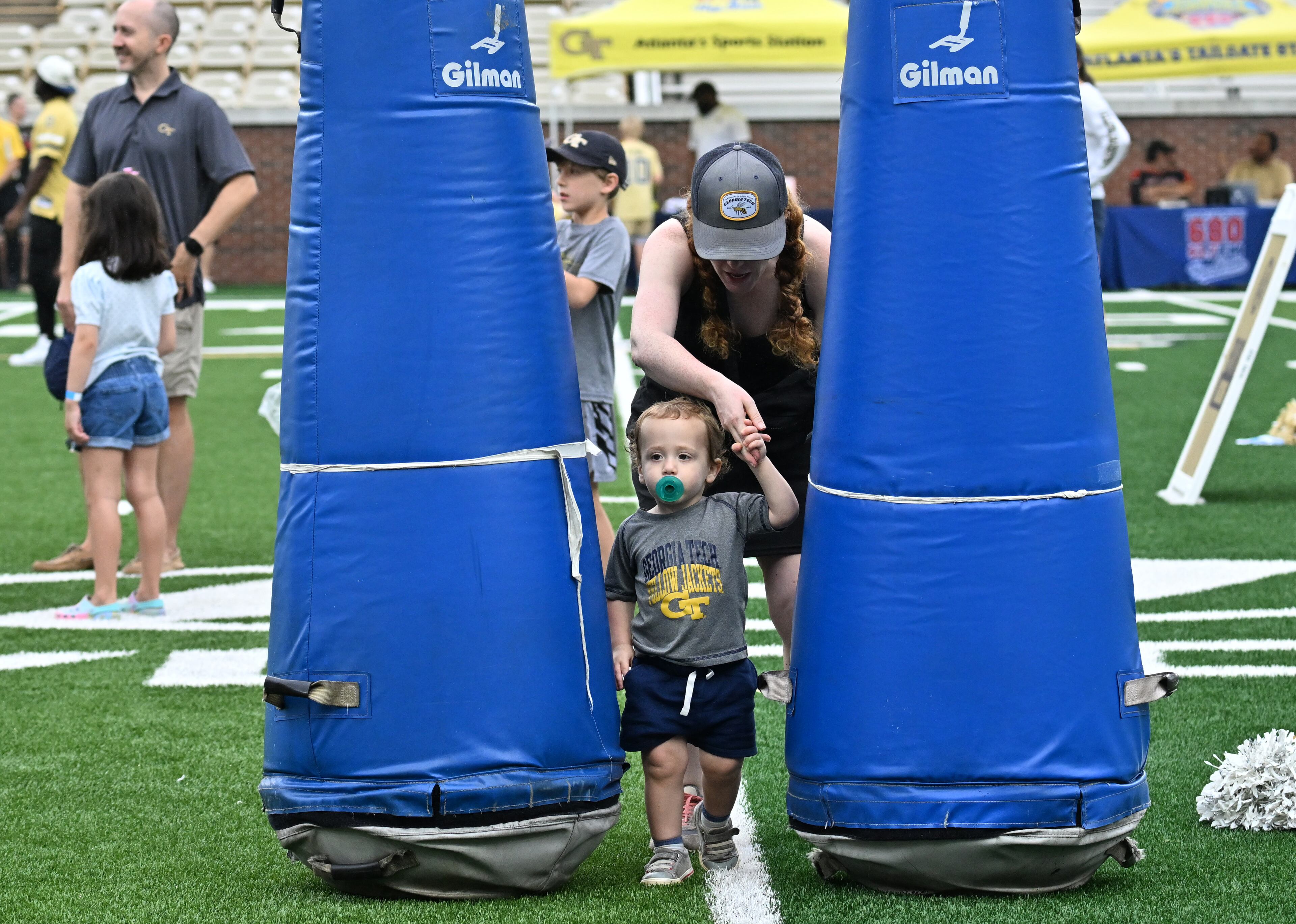 Zola Lopeman and her son Charlie, 2, enjoy a variety of entertaining activities during the annual “First Saturday on The Flats” at Bobby Dodd Stadium, Saturday, August 2, 2025, in Atlanta. The Flats provides Tech fans with the opportunity to engage with their favorite Yellow Jackets ahead of the upcoming 2025 season. The event offers a variety of entertaining activities for the whole family, including a DJ, autograph opportunities, tailgate games and interactive experiences right on the field at Bobby Dodd Stadium. (Hyosub Shin / AJC)