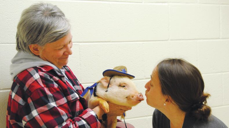 Principal Philpot leans in to give Norma Jean a kiss, as Karen Williams looks on.