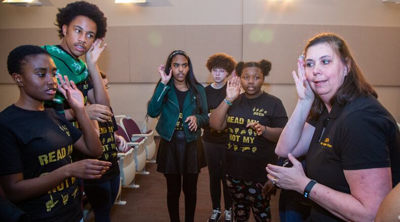 Cecilia Forbes (right) leads the DeKalb Early College Academy Sign Language Club members in practice before they perform Christmas carols while signing during the schools holiday show in Stone Mountain. (Photo by Phil Skinner)