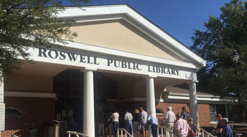 A line of residents participating in early voting snakes outside to the steps of the Roswell Public Library at Norcross Street on Monday, Oct. 17, 2016.