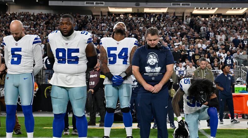 Dallas Cowboys players Bryan Anger (5), Kenny Clark (95), Sam Williams (54), Marist Liufau (35) and Cowboys linebackers coach Dave Borgonzi pause during a moment of silence for teammate Marshawn Kneeland prior to an NFL football game against the Las Vegas Raiders Monday, Nov. 17, 2025, in Las Vegas, in memory of Kneeland who passed away earlier this month. (AP Photo/David Becker)