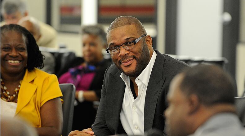 Tyler Perry (center, with Atlanta Mayor Kasim Reed, right) says he won't replace a "fort with a fort" if his plans for redeveloping some 330 acres of Fort McPherson into a film studio come through.
