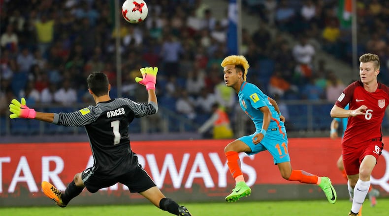 India's Komal Thatal kicks the ball as U.S goalkeeper Justin Garces jumps to block it during their FIFA U-17 World Cup match in New Delhi, India, Friday, Oct. 6, 2017. (AP Photo/Tsering Topgyal)