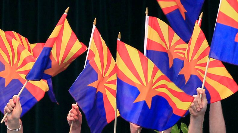 FILE - Members of the Arizona State University Barrett Choir wave Arizona state flags during the celebration of the 100th anniversary of Arizona's statehood, Feb. 14, 2012, in Phoenix.(AP Photo/Ross D. Franklin, File)