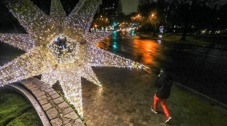 Gerald Stewart walks by a large illuminated holiday display at Peachtree Street and Beverly Road in Midtown Atlanta.