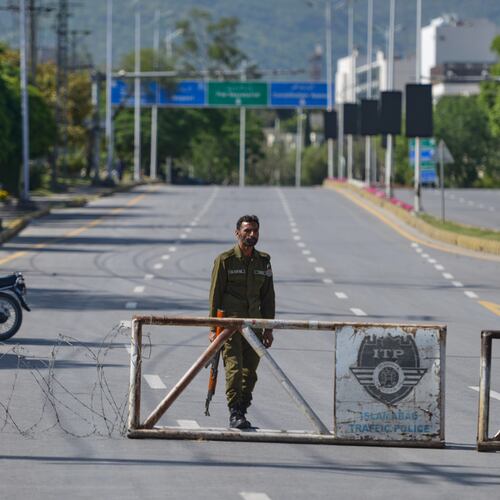 A police officer stands guard at a checkpoint on a barricaded road to ensure security ahead of the second round of the U.S. Iran officials talks, in Islamabad, Pakistan, Sunday, April 19, 2026. (AP Photo/M.A. Sheikh)