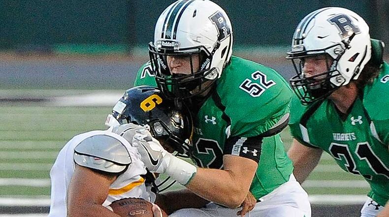 Roswell LB Mitch Stone (52) tackles Central Gwinnett QB Hunter Sims with backup from LB Sam Diroberto (31) during Friday's game.