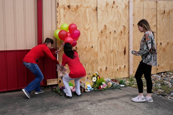 People leave balloons at the scene for victims killed when a car barreled through a building used for an after-school camp, Tuesday, April 29, 2025, in Chatham, Ill. (AP Photo/Erin Hooley)
