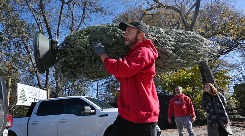 Preparing for the holidays also includes thinking about staying healthy, in addition to trimming the tree. Danny Gorbachov with Tradition Trees helps customers with loading their Christmas tree. (Hyosub Shin / Hyosub.Shin@ajc.com)