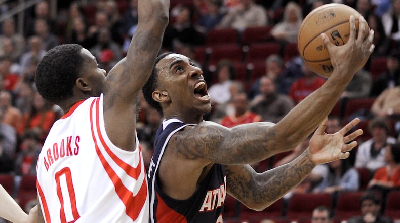 Atlanta Hawks' Jeff Teague, right, goes to the basket guarded by Houston Rockets' Aaron Brooks (0) in the first half of an NBA basketball game Wednesday, Nov. 27, 2013, in Houston.