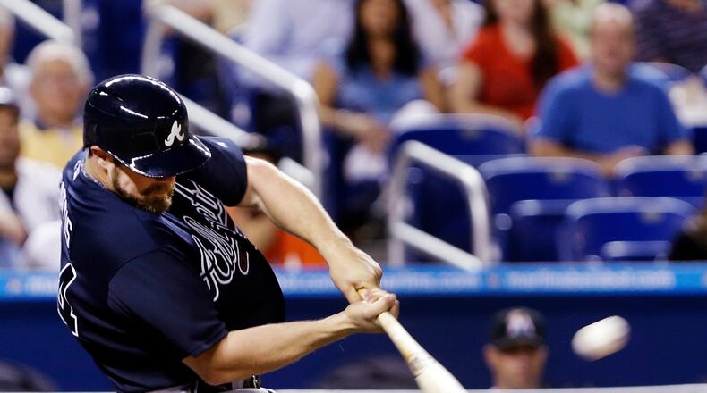 Evan Gattis hits a three-run home run during the fifth inning of a baseball game against the Miami Marlins, Wednesday, April 10, 2013, in Miami. Andrelton Simmons and Jason Heyward scored on the hit.