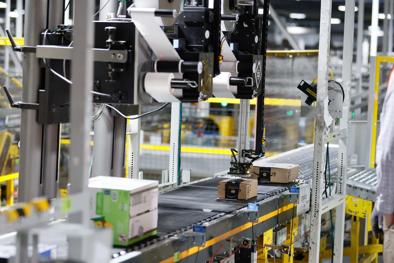 An automated machine is seen placing a sticker on an Amazon package at the Amazon Distribution Center in Stone Mountain. Amazon plans to convert a South Fulton warehouse into a “first mile” fulfillment center to do initial sorting and packaging.
(Miguel Martinez/AJC)