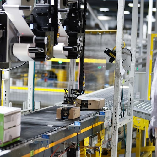 An automated machine is seen placing a sticker on an Amazon package at the Amazon Distribution Center in Stone Mountain. Amazon plans to convert a South Fulton warehouse into a “first mile” fulfillment center to do initial sorting and packaging.
(Miguel Martinez/AJC)