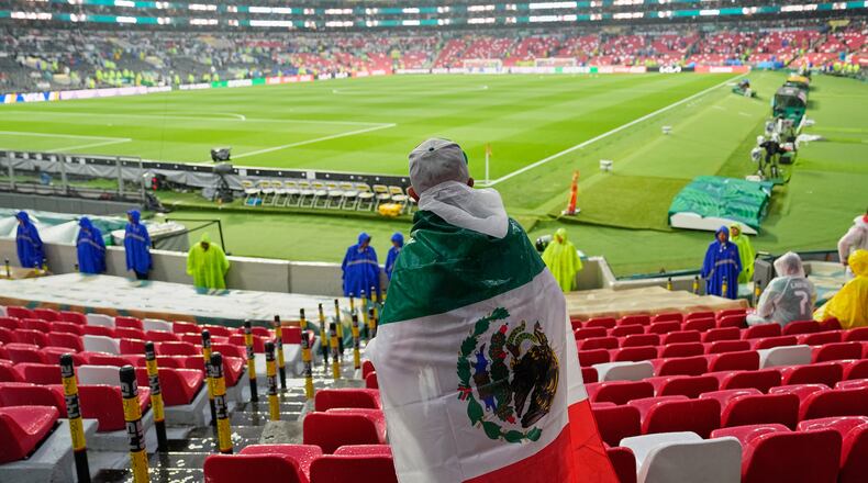 A Mexican fan waits in the rain for the start of the World Cup round of 32 soccer match between Mexico and Ecuador in Mexico City, Tuesday, June 30, 2026. (AP Photo/Natacha Pisarenko )