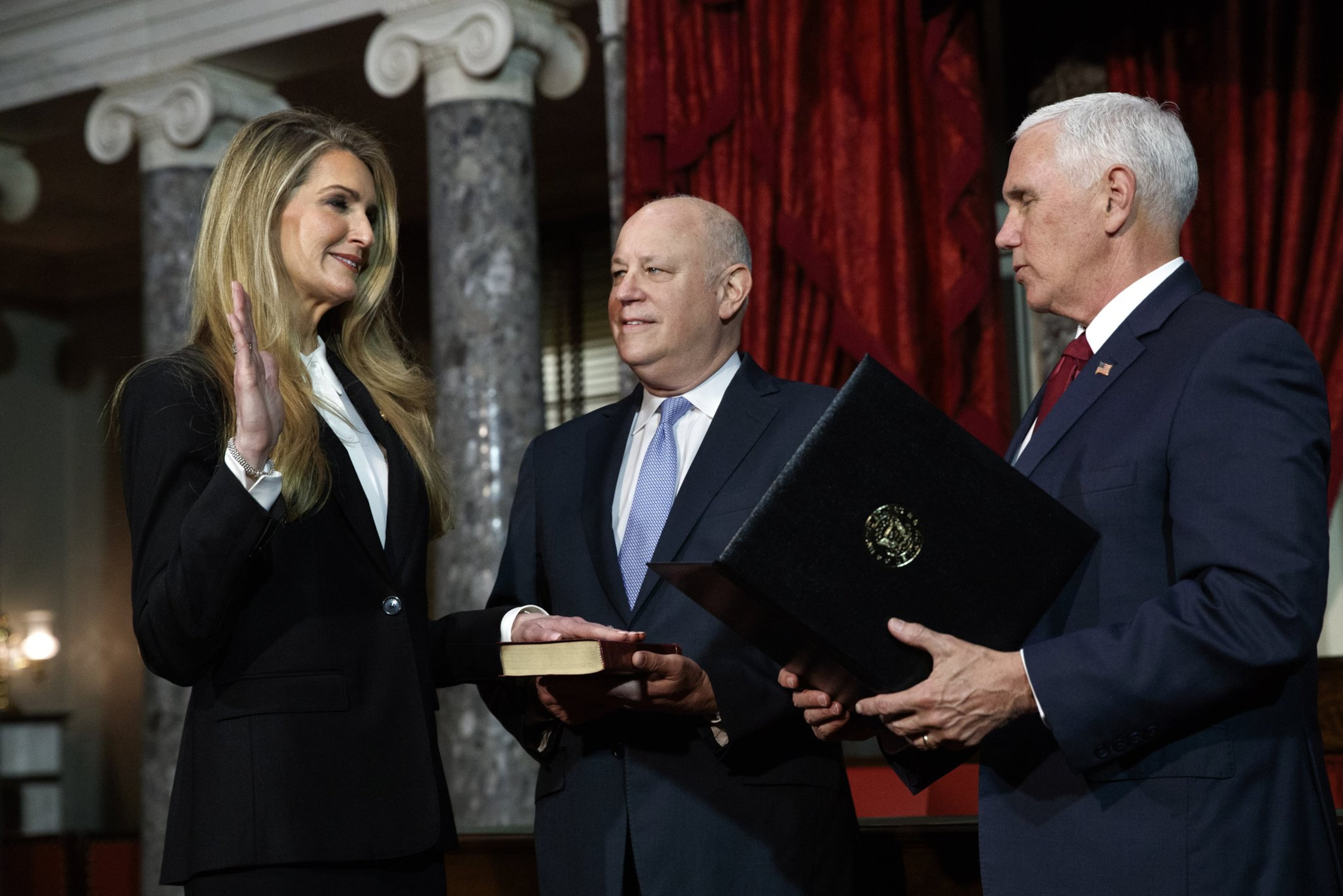 New Republican Sen. Kelly Loeffler of Georgia participates in a re-enactment of her swearing-in Monday with her husband, Jeff Sprecher (center) and Vice President Mike Pence. (Jacquelyn Martin/AP 2020)