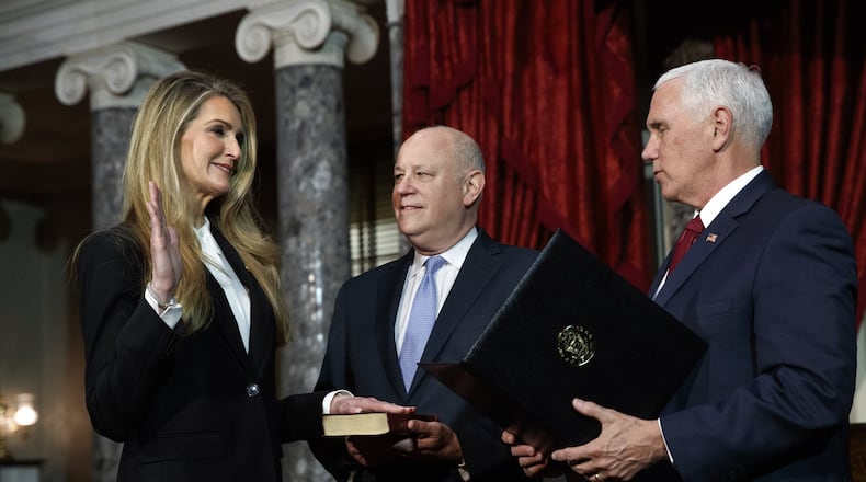 New Republican U.S. Sen. Kelly Loeffler of Georgia participates in a re-enactment of her swearing-in Monday with her husband, Jeff Sprecher, center, and Vice President Mike Pence. Polls show many Georgians still have not formed an opinion about Loeffler, while she’s also drawing scrutiny over how her new duties in the Senate could have an impact on the business dealings of her husband, the chairman and chief executive of Intercontinental Exchange. (AP Photo/Jacquelyn Martin)