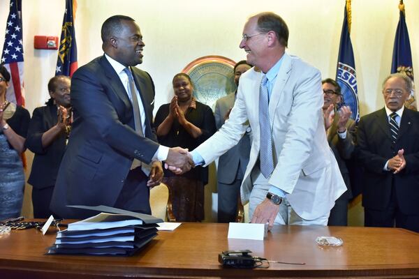 Then-Atlanta Mayor Kasim Reed (left) and Richard Anderson, outgoing CEO of Delta Air Lines, shake hands after signing a new 20-year lease deal for Delta’s operations at Hartsfield-Jackson Atlanta International on April 27, 2016. (Hyosub Shin/AJC 2016)
