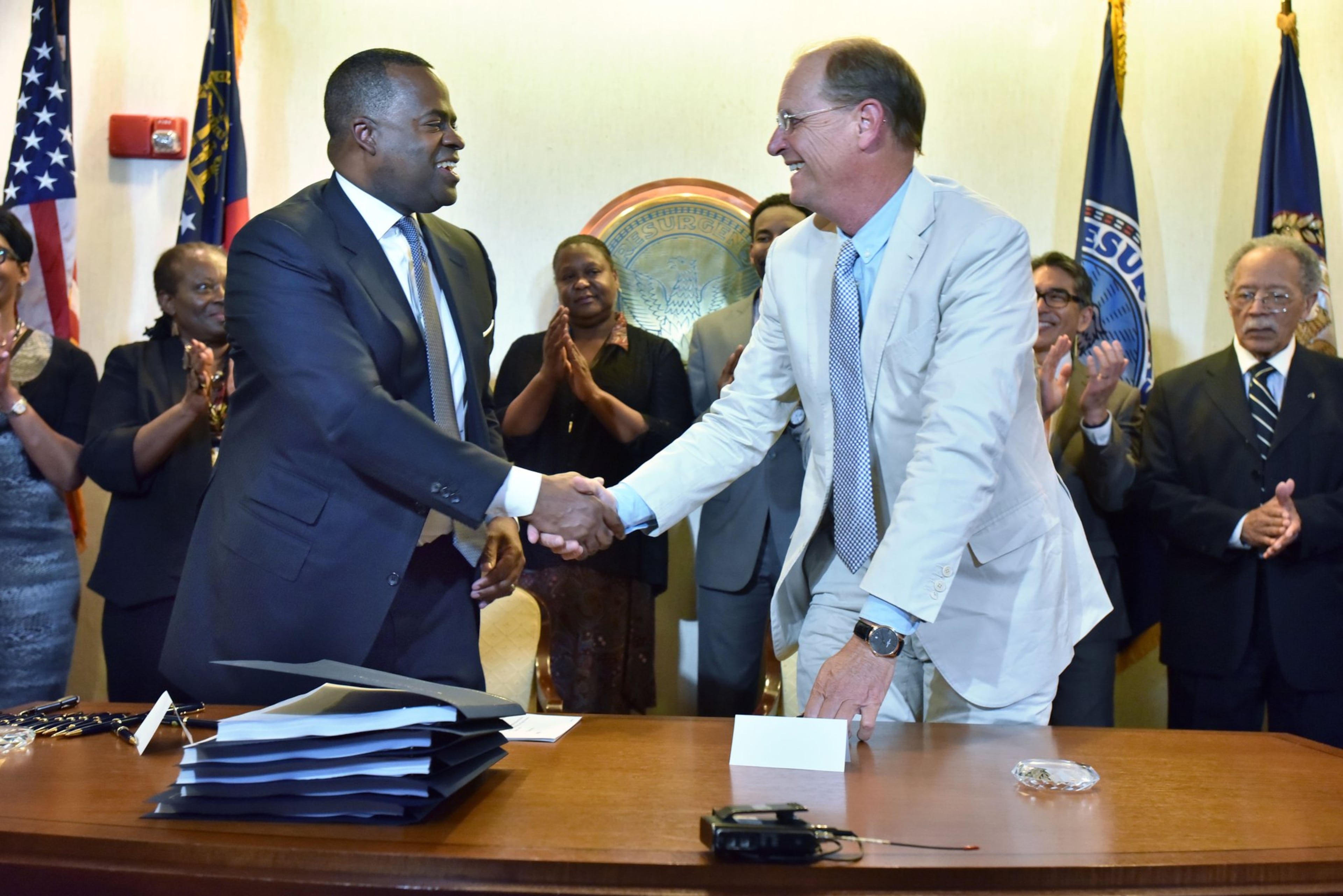 Then-Atlanta Mayor Kasim Reed (left) and Richard Anderson, outgoing CEO of Delta Air Lines, shake hands after signing a new 20-year lease deal for Delta’s operations at Hartsfield-Jackson Atlanta International on April 27, 2016. (Hyosub Shin/AJC 2016)