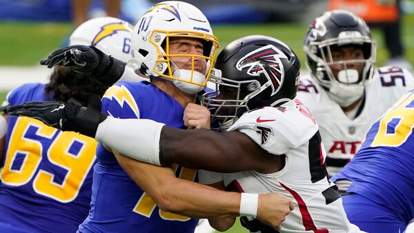 Los Angeles Chargers quarterback Justin Herbert (left) is hit by Atlanta Falcons linebacker Foyesade Oluokun as he throws during the first half Sunday, Dec. 13, 2020, in Inglewood, Calif. (Jae C. Hong/AP)