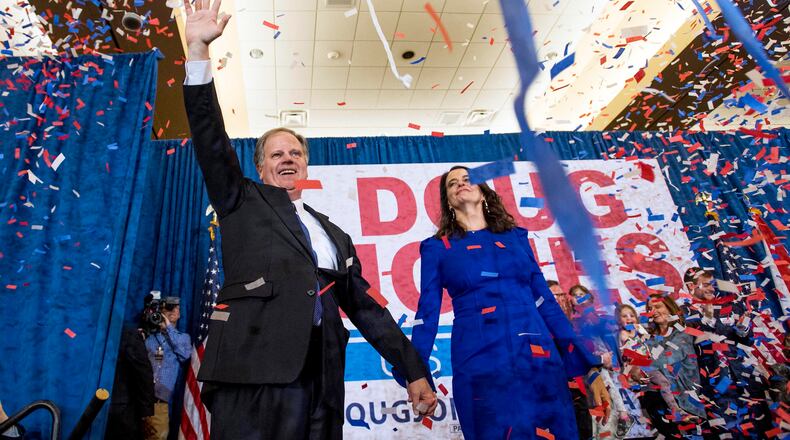 Doug Jones and his wife Louise greet supporters as he claims victory at his watch party in Birmingham.