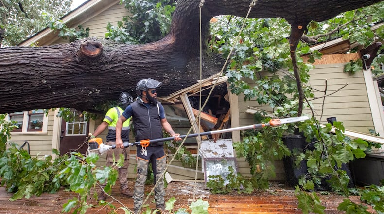 A crew at work removing a fallen tree from an Atlanta area home after Helene swept through the area.