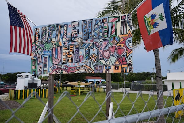 An American and a Haitian flag both hang from a sign reading “Little Haiti Unity” on Wednesday, Aug. 5, 2026, in the Little Haiti neighborhood of Miami. (Lynne Sladky/AP)