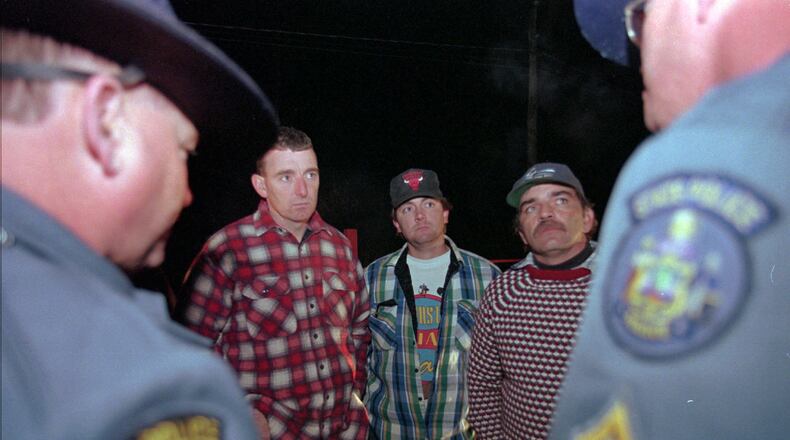 FILE - Maine loggers Stacey Kelly, second from left, Troy Jackson, and Hilton Hafford are threatened with arrest by Maine State Police if they continue to block access to Canadian woodsmen at the border at St. Pamphile, Quebec, Monday, Oct. 26, 1998. (AP Photo/Robert F. Bukaty,File)