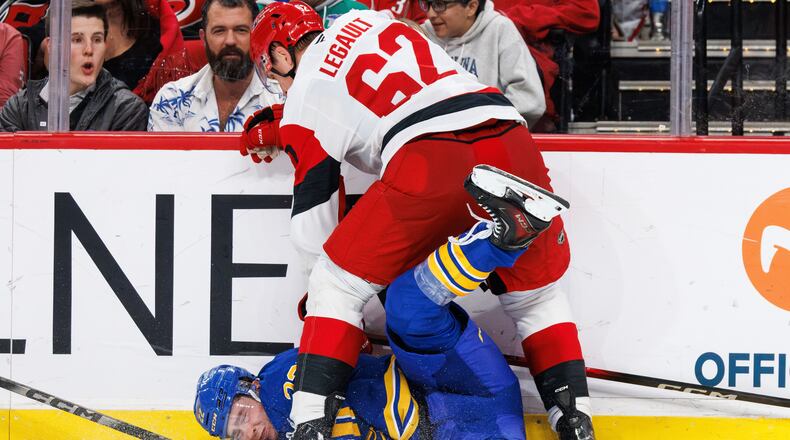 Buffalo Sabres Jack Quinn is knocked to the ice by Carolina Hurricanes Charles Alexis Legault (62) during the third period of an NHL hockey game in Raleigh, N.C., Saturday, Nov. 8, 2025. (AP Photo/Ben McKeown)
