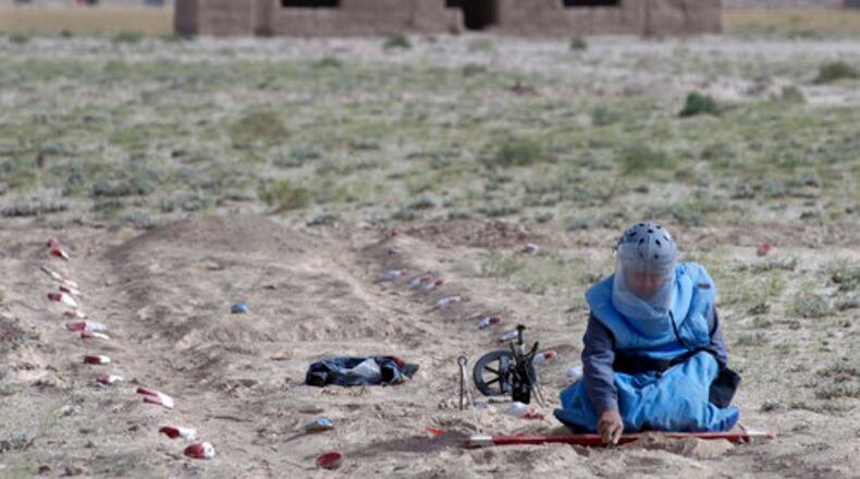 A mining specialist from Afghan Technical Consultants clears a land mine area in Bakhshikhail village in Parwan province north of Kabul, Afghanistan, on Monday. At least 10 people were killed and 16 others wounded in an armed attack on staff members of a British-American charity in Afghanistan that has been clearing land mines in the country for decades, officials said Wednesday.