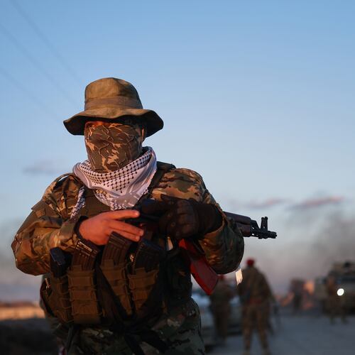 A Syrian government fighter stands guard outside Al-Aqtan prison on the outskirts of Raqqa, northeastern Syria, Monday, Jan. 19, 2026, as negotiations are underway with the Kurdish-led Syrian Democratic Forces over a withdrawal from the prison. (AP Photo/Ghaith Alsayed)