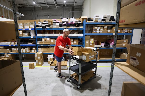 World Micro clerk Tim Prevatt works in the company's Roswell warehouse. World Micro's president and CEO said his business has been hit by tariffs. (Jason Getz / AJC)
