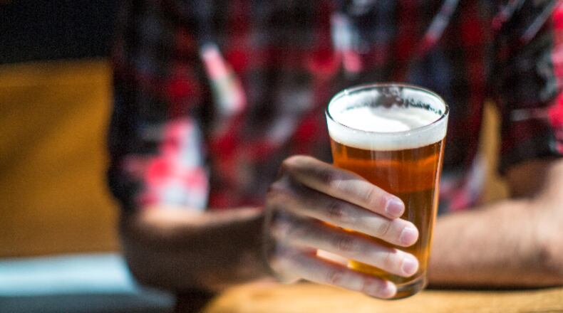 Man holds beer (JTobiasonPhoto / iStock / Getty Images Plus)