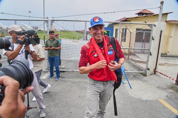 British mountain guide Kenton Cool, center, who scaled Mount Everest Sunday for the 19th time breaking his own record for the most ascents of the world’s highest mountain by a non-Sherpa guide arrives at the airport in Kathmandu, Nepal, Tuesday, May 20, 2025. (AP Photo/Niranjan Shrestha)