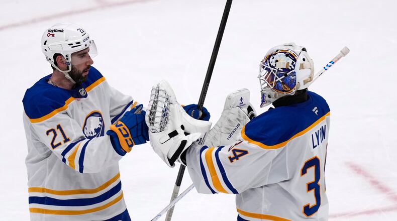 Buffalo Sabres goaltender Alex Lyon (34) is congratulated by Conor Timmins (21) after defeating the Boston Bruins in Game 3 of a first-round NHL hockey Stanley Cup playoff series, Thursday, April 23, 2026, in Boston. (AP Photo/Charles Krupa)