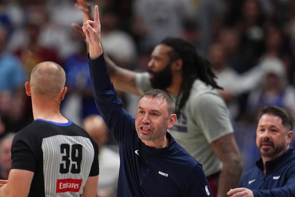 Denver Nuggets interim head coach David Adelman, center, argues for a call with referee Tyler Ford, left, as Nuggets trainer Dan Shimensky, right, comes over to stop him in the first half of Game 4 in the Western Conference semifinals of the NBA basketball playoffs against the Oklahoma City Thunder, Sunday, May 11, 2025, in Denver. (AP Photo/David Zalubowski)