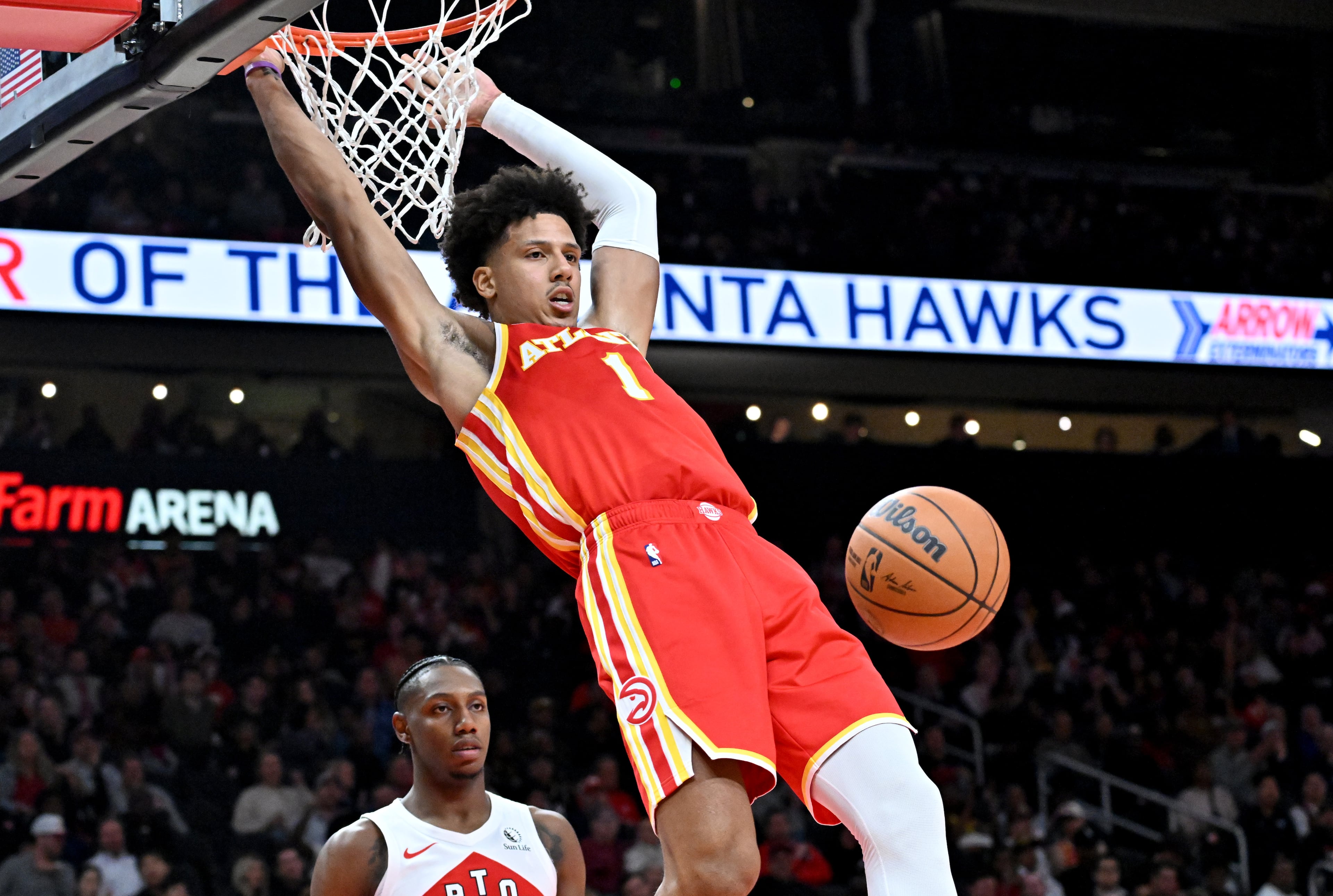 Atlanta Hawks forward Jalen Johnson (1) hangs on the basket after dunking the ball during the second half in the home opener at State Farm Arena, Thursday, October 22, 2025, in Atlanta. Toronto Raptors won 138-118 over Atlanta Hawks. (Hyosub Shin / AJC)