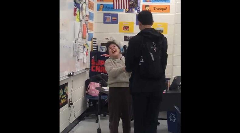 South Forsyth County High School teacher Gloria Green is joyful after student Max Pacheco tells her he was accepted to Georgia Tech. Pacheco surprised her with flowers. PHOTO CREDIT: Max Pacheco.