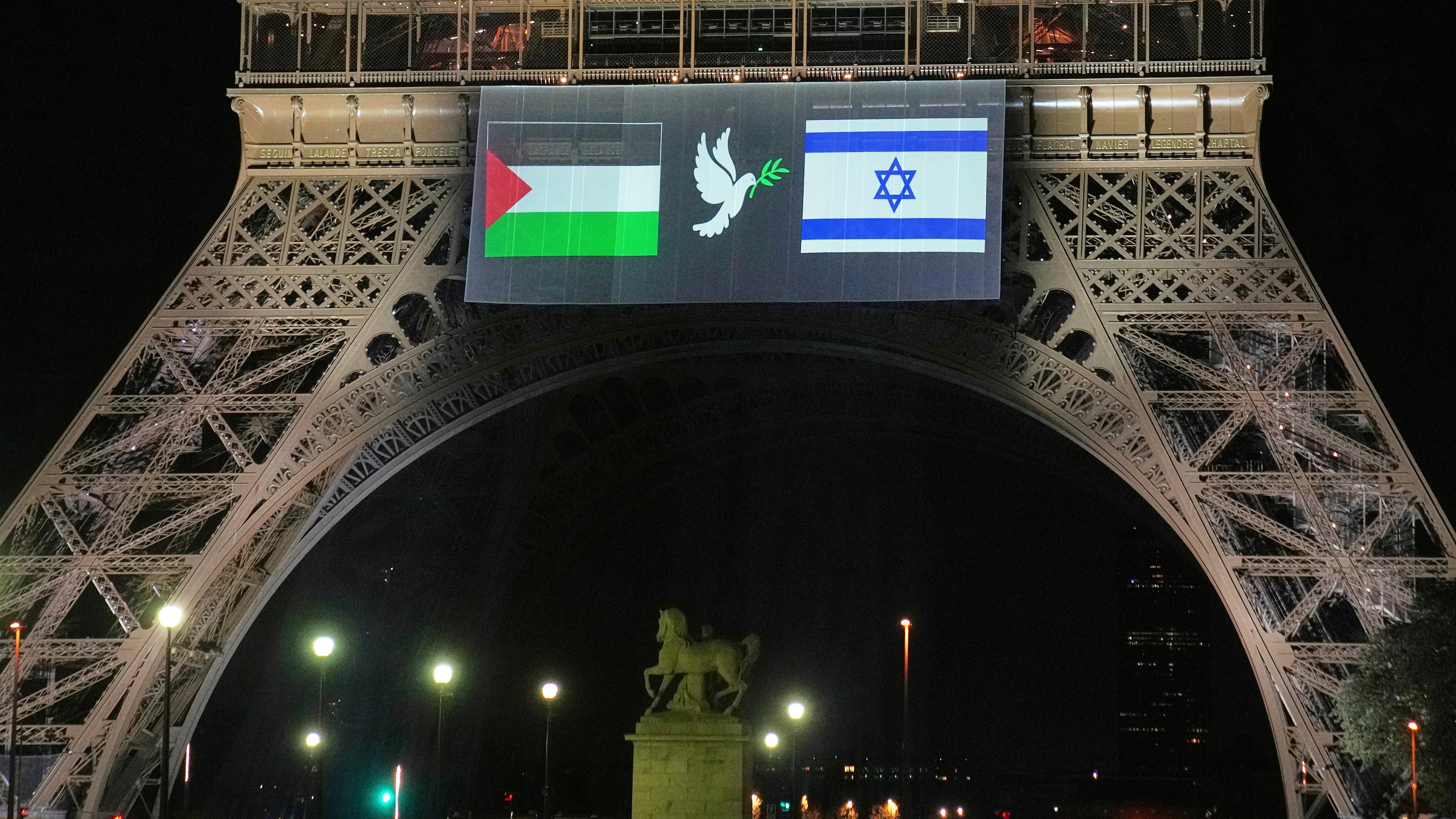 A large screen displays Palestinian and Israeli flags and a dove on the Eiffel Tower, Sunday, Sept. 21, 2025, in Paris, as France prepares to formally recognize a Palestinian state at the United Nations General Assembly. (AP Photo/Christophe Ena)
