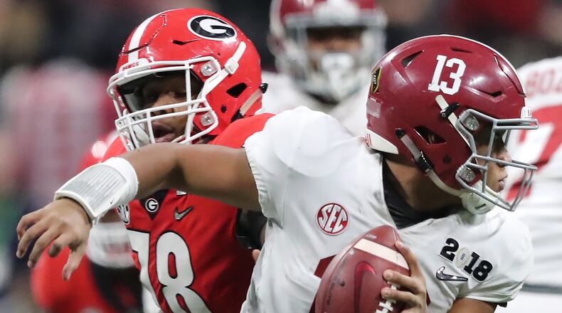 Alabama quarterback Tua Tagovailoa scrambles away from the pressure by Georgia defensive tackle Trenton Thompson to get off a pass on a touchdown drive during the fourth quarter that tied the game 20-20 in the College Football Playoff National Championship on Monday, January 8, 2018, in Atlanta. Curtis Compton/ccompton@ajc.com