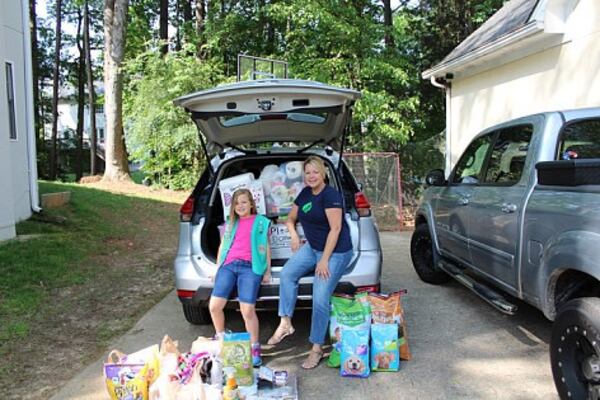  Faith Beckett, 10, and her mom Alicia Beckett, a Girl Scout leader, with items collected for a recent donation driver.