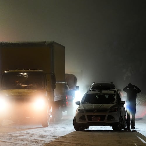 A motorist exits a vehicle during a snow storm Wednesday, Feb. 18, 2026, in Placer County, Calf. (AP Photo/Godofredo A. Vásquez)