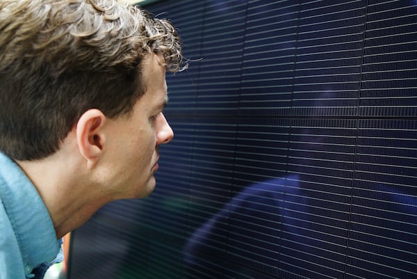 Will Etheridge, CEO of Southern Energy Management, looks at a solar panel that will be installed on James Asbill's home in Chapel Hill, N.C., Wednesday, July 2, 2025. (AP Photo/Allen G. Breed)