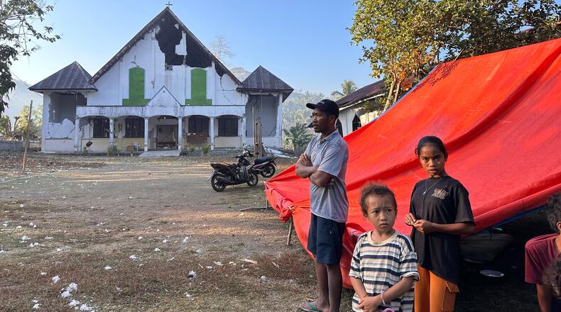 Earthquake survivors stand outside their tent erected near a damaged church in Satar Punda, East Nusa Tenggara province, Indonesia, Tuesday, Aug. 18, 2026. (AP Photo/Firdia Lisnawati)